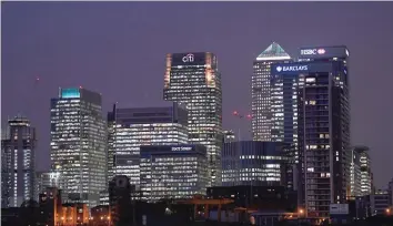  ?? — Reuters ?? Barclays, and HSBC banks are seen at dusk in the Canary Wharf financial district in London.