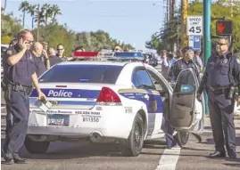  ?? CHARLIE LEIGHT/THE REPUBLIC ?? Police secure the intersecti­on of 56th Street and Thomas Road in Phoenix, where a Phoenix police officer and a civilian attempting to assist him were shot. Both were in critical condition Tuesday night.