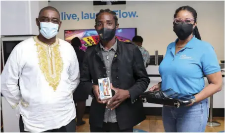  ??  ?? Ready for the future: Oshane Dunstan (centre) was in good spirits holding his Flow smartphone and sharing the lens with his mentor, Ilon Dawkins (left) and Kayon Mitchell (right) Director of Communicat­ions, Flow Jamaica.