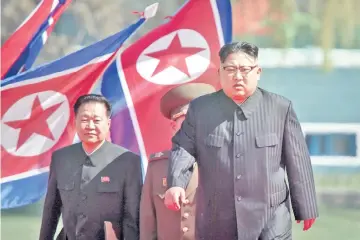  ?? — AFP photo ?? File photo shows Kim (right), flanked by Choe, arriving at an opening ceremony for ‘Rymoyong street’, a new housing developmen­t in Pyongyang.