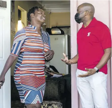  ??  ?? Alterine Shaw-grant is greeted with the good news by Peter Mohan, Scotiabank branch manager, at her home. Shaw Grant received $60,000 in grocery vouchers , two laptops and a tablet to assist her and her three children who are now doing online classes.