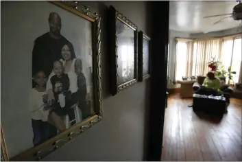  ?? PHOTOS BY MARTHA IRVINE — THE ASSOCIATED PRESS ?? With family photos seen in the foreground, Dianne Green works on an art project in her home in Chicago on March 24. Green, a retiree and cancer survivor, said she struggled with loneliness after several family members died in 2019 and early 2020. Then the pandemic hit. Even before the lockdowns, a survey found that 61 percent of American adults said they were lonely. A year of added isolation highlighte­d a problem that health officials say is as harmful as smoking.