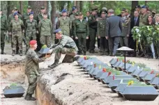  ?? WOLFGANG KUMM, EUROPEAN PRESSPHOTO AGENCY ?? Russian and German soldiers take part in a reburial ceremony Tuesday in Halbe, Germany, for 71 German soldiers who died in WWII. The ceremony was attended by German Defense Minister Ursula von der Leyen and other officials from both nations.