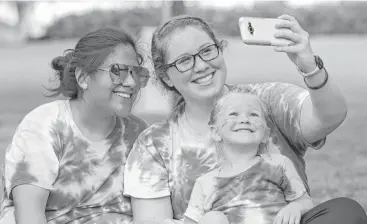  ?? Yi-Chin Lee / Houston Chronicle ?? Anna Weaver, right, takes a selfie with her wife, Ruth, and 4-year-old son, Ezra, at the Rainbow on the Green musical event Friday. Saturday’s pride parade will feature an HPD patrol unit emblazoned with rainbow decals.