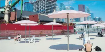  ??  ?? People practise physical distancing as they enjoy the hot weather at Sugar Beach in Toronto. Environmen­t Canada has issued heat warnings this week for much of Ontario, where temperatur­es are hovering at about 30 C.