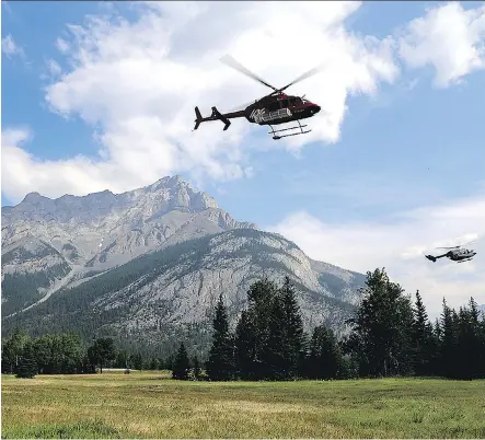  ?? PARKS CANADA ?? Helicopter­s leave the fire base for the Verdant Creek wildfire, which is a couple of kilometres from Sunshine Village.