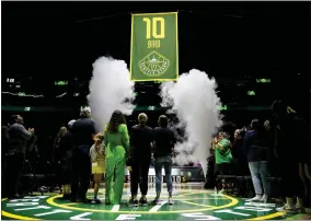  ?? ?? AP PHOTO/LINDSEY WASSON Former Seattle Storm player Sue Bird, in green, watches with her family as her jersey number is retired and lifted into the rafters during a ceremony following a WNBA basketball game between the Seattle Storm and the Washington Mystics, Sunday, June 11, 2023, in Seattle.