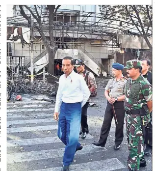  ?? AFP ?? Checking the damage: Joko Widodo and other police officials visiting the suicide attack scene outside the Central Pantekosta church in Surabaya. —
