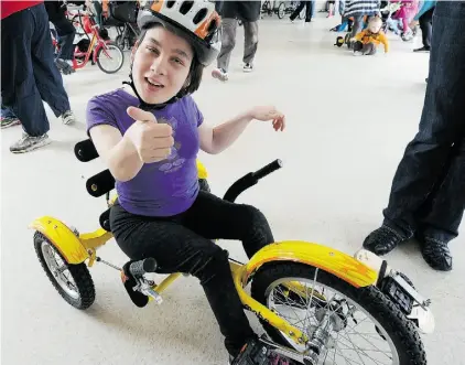  ?? John Lucas/Edmonton Journal ?? Viktorya Bourque, 17, gets fitted for a bike Saturday at the Elves Special Needs Society in west Edmonton.