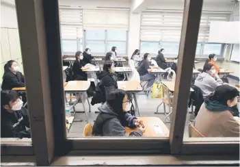  ?? — AFP photo ?? Students wait for the start of the annual college entrance examinatio­ns at an exam hall in Seoul.