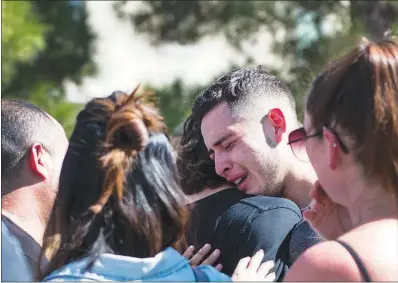  ?? PHOTOS BY RICARDO TORRES-CORTEZ ?? A mourner is consoled Saturday as he cries at the Liberty at Paradise community in southeast Henderson. He and others were there for a ceremony honoring Selina Rowsell, her son, Arias, and his younger brother, Avi. The three were slain Thursday at their home in the same community.