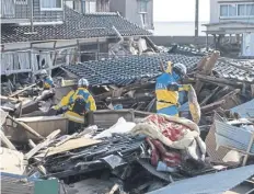  ?? ?? Japanese police search for missing persons after the quake