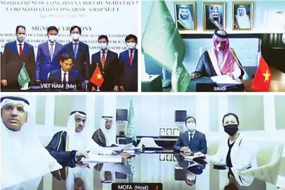  ??  ?? Saudi Foreign Minister Prince Faisal bin Farhan signs a MoU during an online meeting with his Vietnamese counterpar­t Bui Thanh Son. SPA