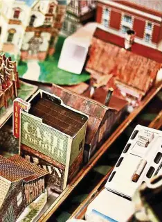  ??  ?? Paper churches and buildings stacked on trays in Kellison’s home before an upcoming fundraisin­g event.