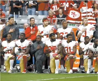  ??  ?? Les joueurs des 49ers de San Francisco ont trouvé une nouvelle façon de manifester contre les injustices raciales, dimanche. - Associated Press: Ross D. Franklin