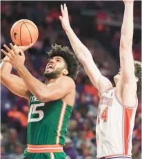  ?? SEAN RAYFORD/AP ?? Miami forward Norchad Omier puts up a shot against Clemson center PJ Hall during Saturday’s game in Clemson, South Carolina.