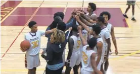  ?? KYLE J. ANDREWS/BALTIMORE SUN ?? Dunbar players huddle together with interim coach and athletic director Dana Johnson on Thursday night.