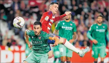  ?? ?? Postigo y Callejón pugnan por un balón aéreo ayer en Los Cármenes.