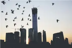  ??  ?? The sun sets behind the Central Business District with the CITIC Tower at it’s centre in Beijing, China. — Reuters photo