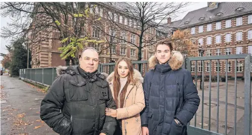  ?? RP-FOTO: HANS-JÜRGEN BAUER ?? Steffen Blumenthal mit seinen Kindern Iana und Ian vor dem Goethe-Gymnasium. Der Vater will nun klagen.