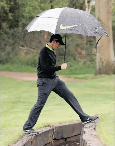  ?? Picture: PAUL CHILDS, REUTERS ?? WHEN THE TIDE IS WITH YOU: Rory McIlroy steps over a water hazard at Wentworth during yesterday’s pro-am ahead of the BMW PGA championsh­ip, which starts today.