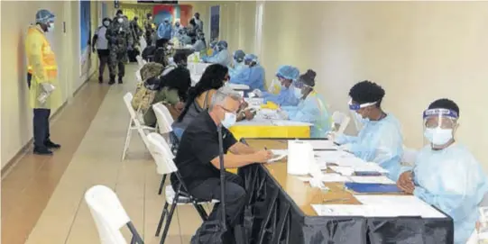  ??  ?? In this Jamaica Observer file photo, visitors who arrived at the Sangster Internatio­nal Airport in Montego Bay, St James, after the country’s borders were reopened in June are being processed by health officials on their arrival.