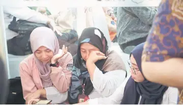  ??  ?? Family members of victims of the ill-fated Lion Air flight JT 610 gather at a disaster victim identifica­tion unit at a police hospital in Jakarta.