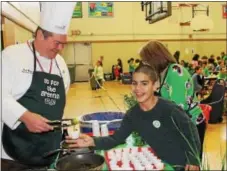  ?? DIGITAL FIRST MEDIA FILE PHOTO ?? Ian Acosta, 11, smiles for the camera as he accepts a sauteed Brussels sprout from Chef Richard Ray at East Vincent Elementary. Owen J. Roberts School District celebrated “Go for the Greens” week.