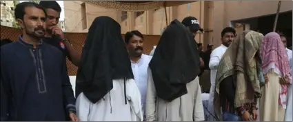  ?? AP Photo/FAreed KhAn ?? In this Aug. 10, file photo, family members of suicide bomber Hafeez Nawaz, with their faces covered, are presented before media for in Karachi, Pakistan. Nawaz killed 149 people and wounded 300 others.