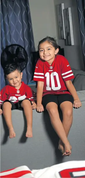  ??  ?? Left: Sergio Carmona, his wife Elizabeth, son Sergio Jr., 3, and daughter, Myah, 7, right, showcase their San Francisco 49ers jerseys. Carmona has 21 49ers jerseys in his collection and his family’s collection totals more than 30 uniform tops.