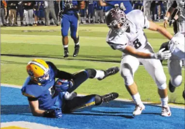  ?? PETE BANNAN — DAILY LOCAL NEWS ?? Downingtow­n East wide receiver Cary Angeline scores in the first quarter as Brian Armstrong of West Chester Henderson defends during Friday’s Ches-Mont League National Division contest.