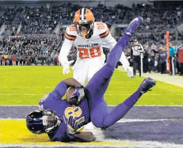  ?? KENNETH K. LAM/BALTIMORE SUN ?? The Ravens’ Breshad Perriman catches a 27-yard touchdown pass in front of the Browns’ Briean Boddy-Calhoun in the fourth quarter of Thursday night’s 28-7 victory. Perriman had three catches in the game, tying his personal best.