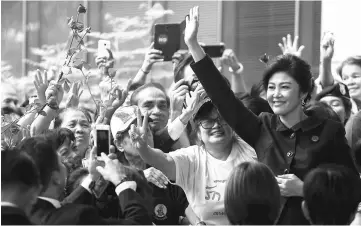  ??  ?? Yingluck greets supporters as she arrives at the Supreme Court in Bangkok. — Reuters photo