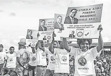  ??  ?? Youths carry posters depicting the contents of the ruling Democratic Progressiv­e Party’s (DPP) manifesto during the official launch of its election campaign led by Malawi’s President at Kamuzu Institute for Sports in Malawi’s capital Lilongwe, ahead of next month’s elections. — AFP photo