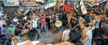  ??  ?? Syrer in Binnish, östlich der Provinzhau­ptstadt Idlib, jubeln und schwenken eine türkische Fahne.