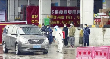  ?? AP ?? A worker in protective overall disinfects a vehicle from the World Health Organizati­on convoy while experts investigat­ing the origins of the COVID-19 pandemic are visiting the Baishazhou wholesale market on the third day of their field visit in Wuhan in central China’s Hubei province yesterday.