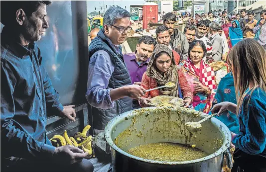  ?? ATUL LOKE FOR THE NEW YORK TIMES ?? Rahul Verma has taken a stand against junk food in India. Distributi­ng a traditiona­l dish outside a hospital in New Delhi.