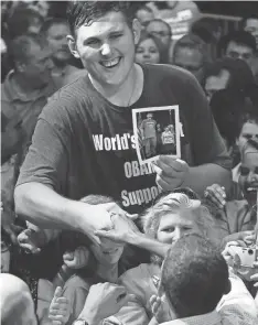  ?? BEN GARVIN/AP ?? President Barack Obama, foreground, reaches up to shake the hand of 7-foot-8 Igor Vovkovinsk­iy during a rally Sept. 12, 2009. Vovkovinsk­iy died Friday of heart disease.