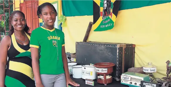  ?? PHOTOS BY ORANTES MOORE ?? Teacher Annief Ashman and grade-six student D’janae Davis present antiques, including a typewriter, chamber pot, and video cassette collected by students at Beecham Hill Primary and Infant School in St Mary as part of their Jamaica Day celebratio­ns.