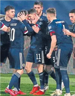  ??  ?? Ryan Christie is mobbed after the penalty shootout drama.