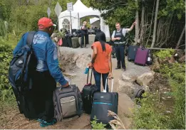  ?? CHARLES KRUPA/AP 2017 ?? A Royal Canadian Mounted Police officer informs a migrant couple of the location of a legal
illegally. border station, shortly before they crossed over to Quebec