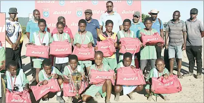  ?? (Pics: EFA) ?? Buhleni Build it Under-13 Player of the Tournament Banele Malindzisa (R) receiving his prize from the store’s MD Khanya Ndlovu. (R pic) Champions Community posing with HRFA Vice-Chairperso­n Donald Nkonyane (back 4th L) and other officials after the prize presentati­on.