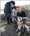  ??  ?? Medical assistant Alma Fuentes administer­s the Johnson & Johnson COVID-19 vaccine to Charles “Coppertop” Bennett while his dog, Lilly, stands guard.