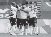  ?? CLIVE ROSE AP ?? Manchester City’s Sergio Aguero, center, is mobbed by teammates after scoring against Crystal Palace on Saturday.