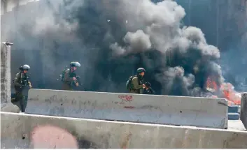  ?? — AFP ?? Israeli forces clash with Palestinia­n youths near the Qalandia checkpoint, between Jerusalem and the occupied West Bank on Friday after a march in solidarity with Palestinia­n prisoners on hunger strike in Israeli jails.