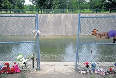  ?? [MIKE SIMONS/ TULSA WORLD] ?? A makeshift memorial has been created at the spot where Miracle Crook, 3, and Tony Crook, 2, walked down to Mingo Creek at the Shoreline Apartments.