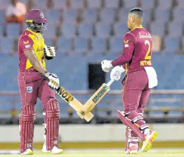  ?? CWI MEDIA ?? West Indies batsmen Dwayne Bravo (left) and Shimron Hetmyer celebrate a boundary during their second Twenty20 Internatio­nal match against Australia in Gros Islet, St Lucia, on Saturday, July 10.