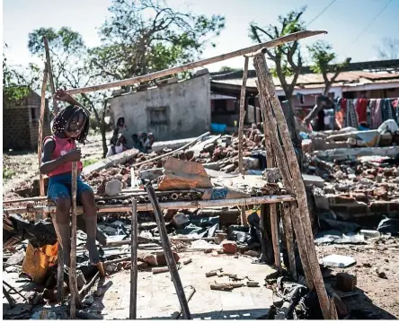  ?? — Photo: aFP ?? a girl sits on a kiosk destroyed by the cyclone Idai in Tica, Mozambique. The cyclone smashed into Mozambique’s coast unleashing hurricane-force wind and rain that flooded swathes of the poor country before battering eastern Zimbabwe, killing 705 people across the two nations.