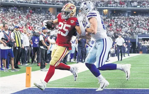  ?? AFP ?? The 49ers’ Elijah Mitchell, left, scores a touchdown against the Cowboys during a wild-card round game in Arlington on Sunday.