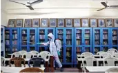  ?? — PRITAM BANDYOPADH­YAY ?? A worker sanitises a classroom at a school ahead of its reopening Kolkata on Monday.